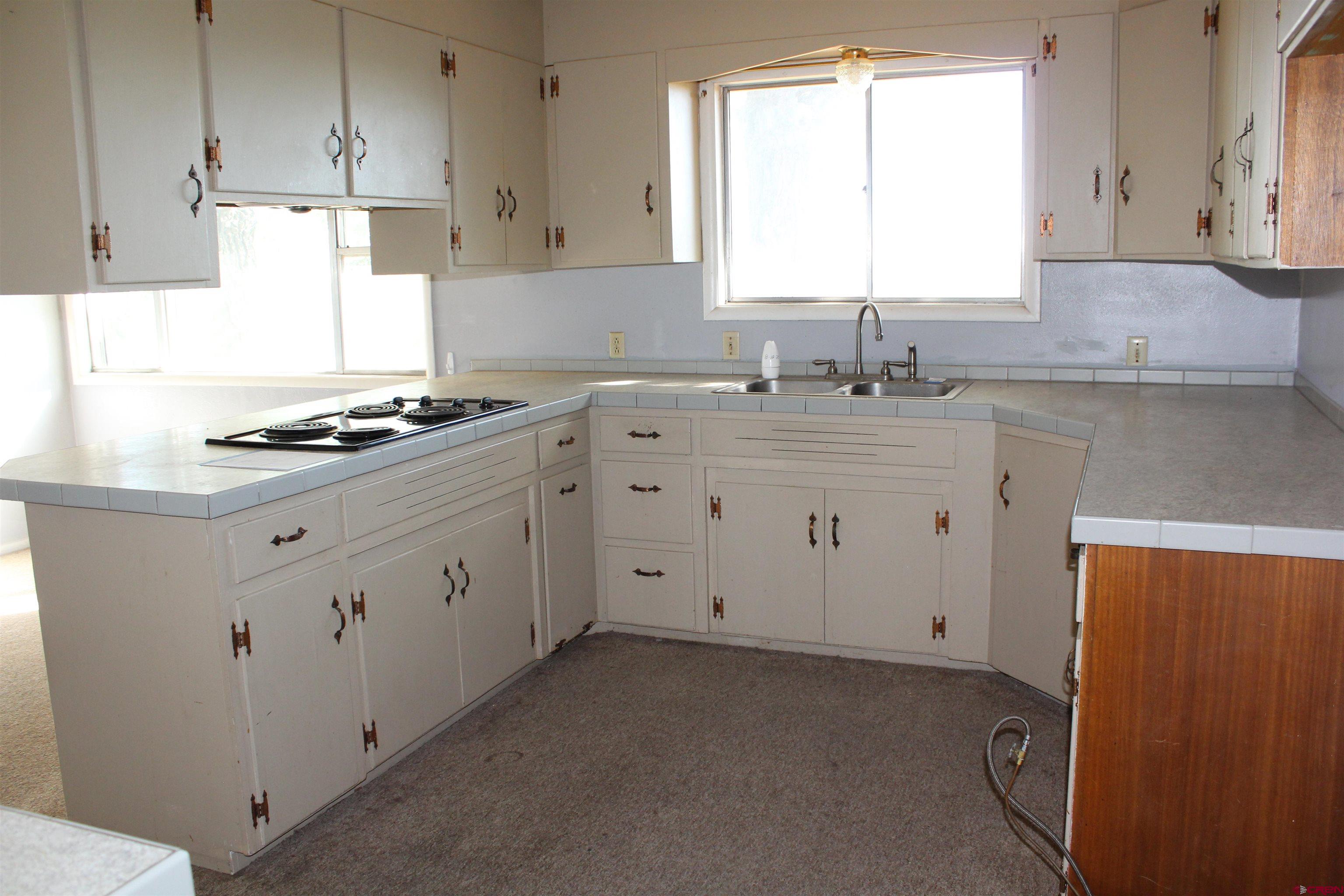23892 County Rd M Cortez, CO 81321 - Photo 12 of 27 a kitchen with granite countertop white cabinets and white appliances