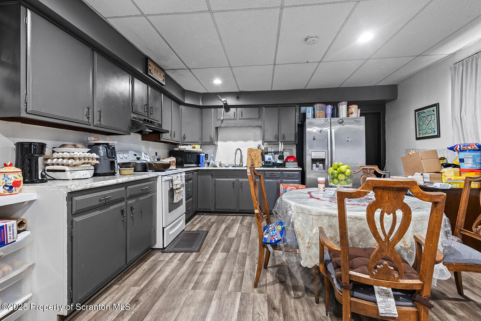 511 Fig Street Scranton, PA 18505 - Photo 18 of 33 a kitchen with stainless steel appliances granite countertop a stove a refrigerator a sink dishwasher a dining table and chairs with wooden floor