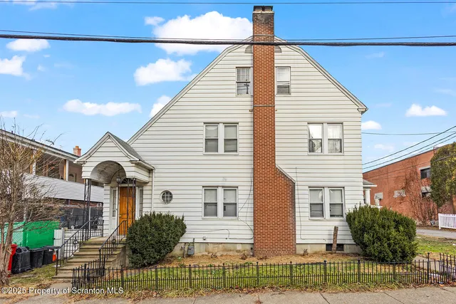 a view of a brick house with large windows