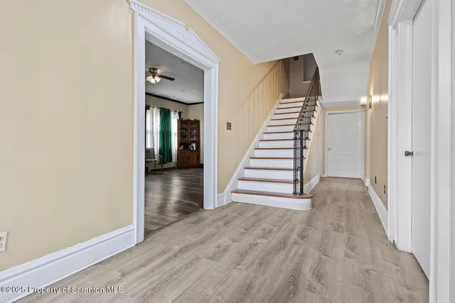 a view of a hallway with wooden floor and staircase