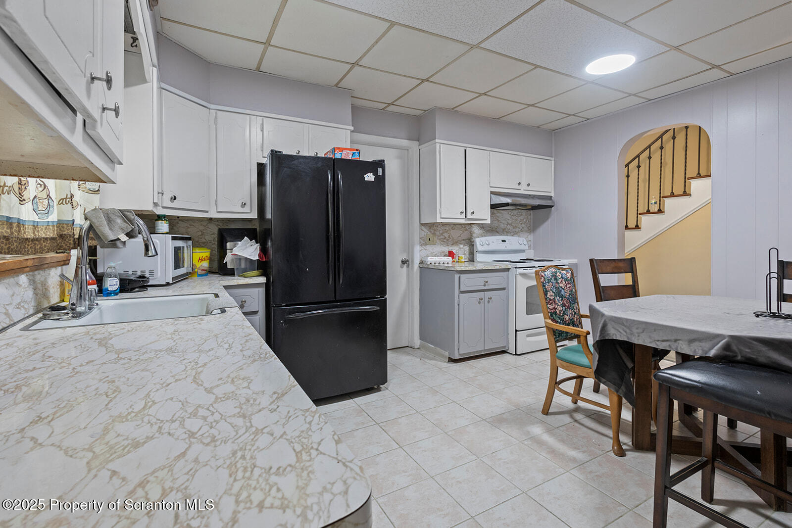 511 Fig Street Scranton, PA 18505 - Photo 5 of 33 a kitchen with stainless steel appliances a refrigerator a stove a sink dishwasher with a dining table and chairs