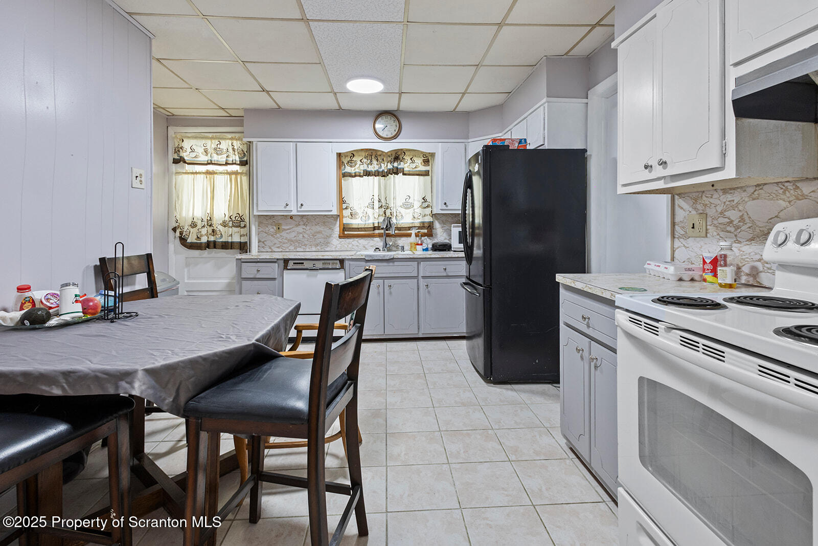 511 Fig Street Scranton, PA 18505 - Photo 6 of 33 a kitchen with a refrigerator a stove a dining table and chairs