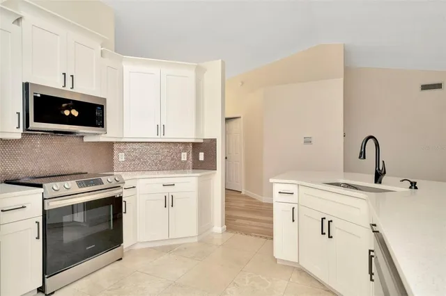a kitchen with white cabinets and stainless steel appliances