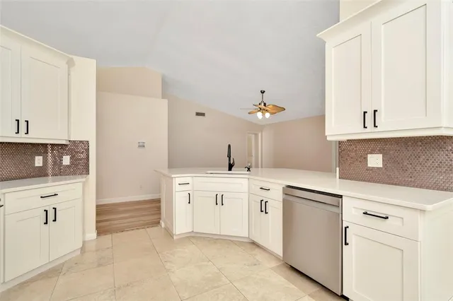 a kitchen with white cabinets and appliances