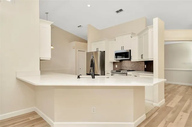 a kitchen with stainless steel appliances a refrigerator sink and microwave