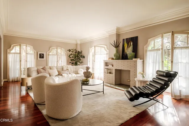a living room with furniture fireplace and wooden floor
