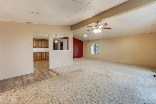 a view of a big room with windows and chandelier fan