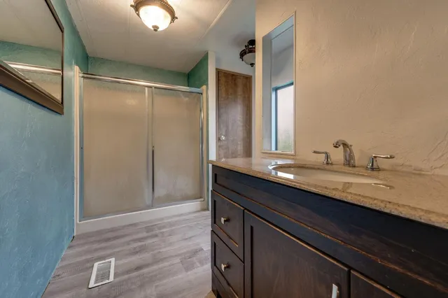a bathroom with a granite countertop sink and a mirror