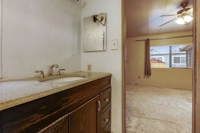 a bathroom with a granite countertop sink a toilet and a mirror