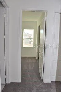a view of an empty room with window and closet