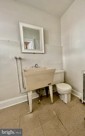 a bathroom with a toilet a sink and mirror