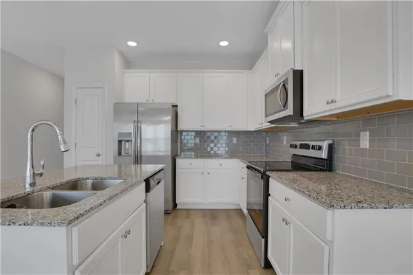 a kitchen with stainless steel appliances granite countertop a sink stove and refrigerator