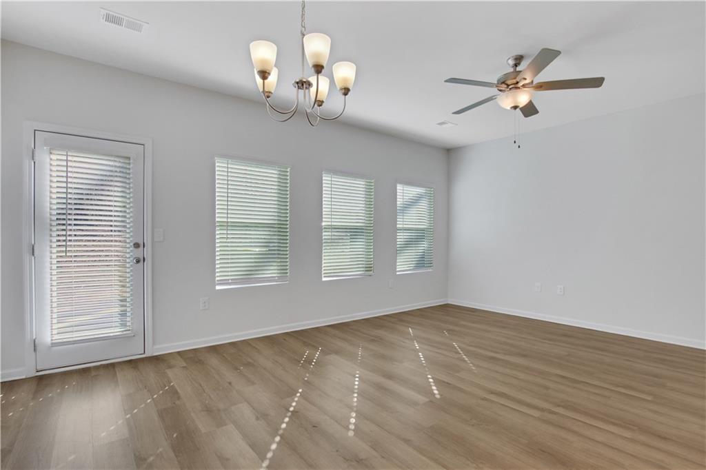 102 Jaxton Street Hoschton, GA 30548 - Photo 13 of 36 a view of an empty room with wooden floor and a window