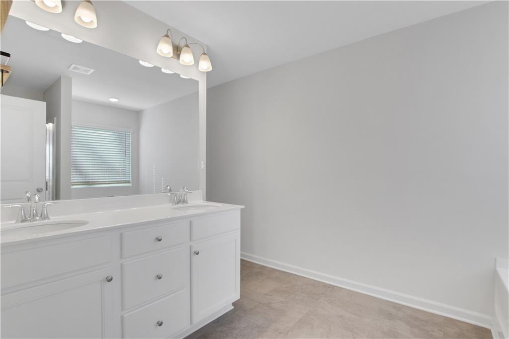 102 Jaxton Street Hoschton, GA 30548 - Photo 23 of 36 a bathroom with a double vanity sink and a mirror