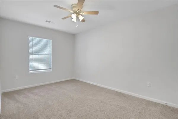an empty room with a window and a fan