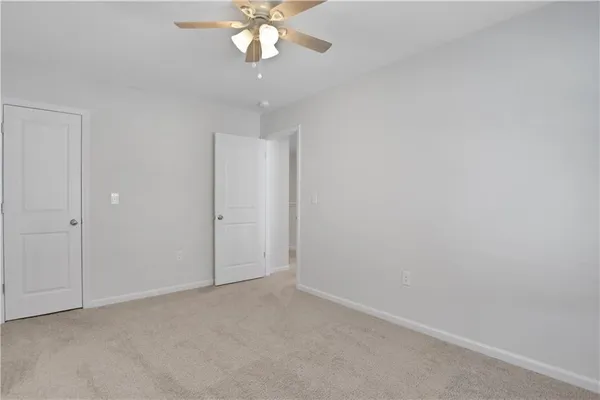 an empty room with a chandelier fan