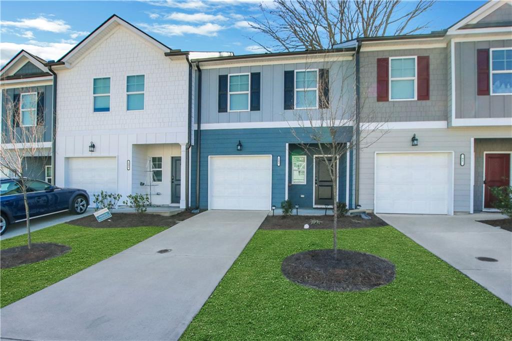 102 Jaxton Street Hoschton, GA 30548 - Photo 3 of 36 a front view of a house with a yard and garage