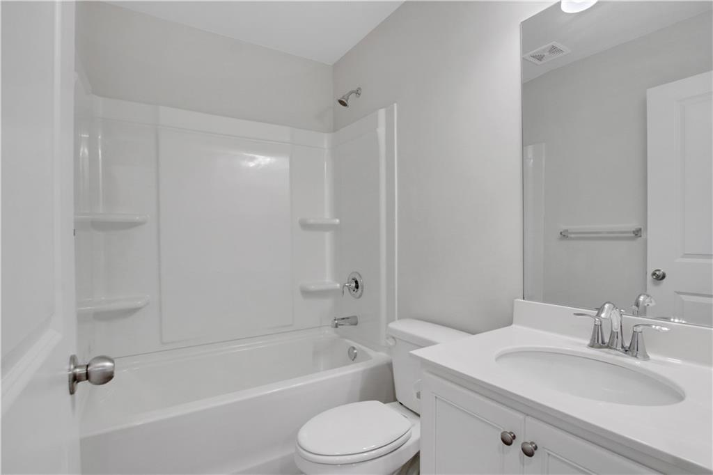 102 Jaxton Street Hoschton, GA 30548 - Photo 31 of 36 a bathroom with a bathtub shower sink vanity mirror and toilet