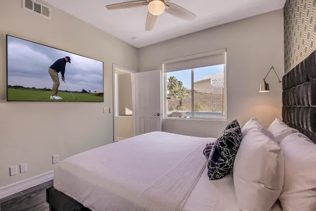 a bedroom with a bed wooden floor and window