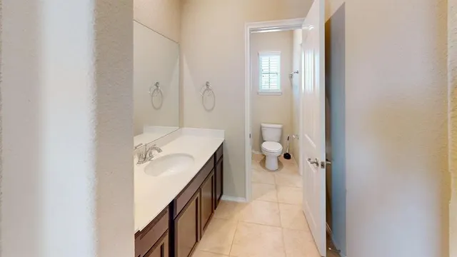 a bathroom with a sink and mirror with toilet