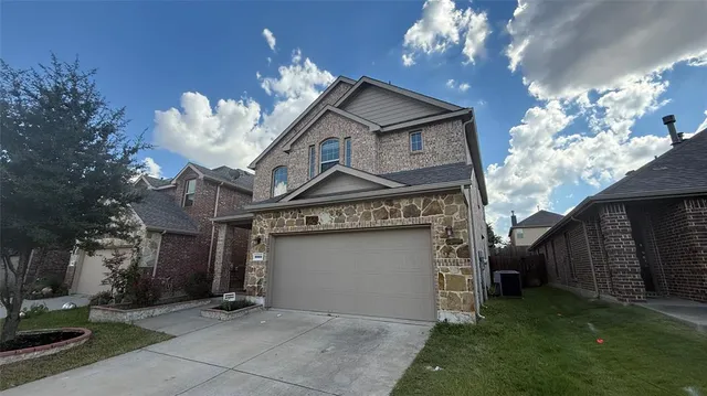 a view of a house with a large tree and a yard