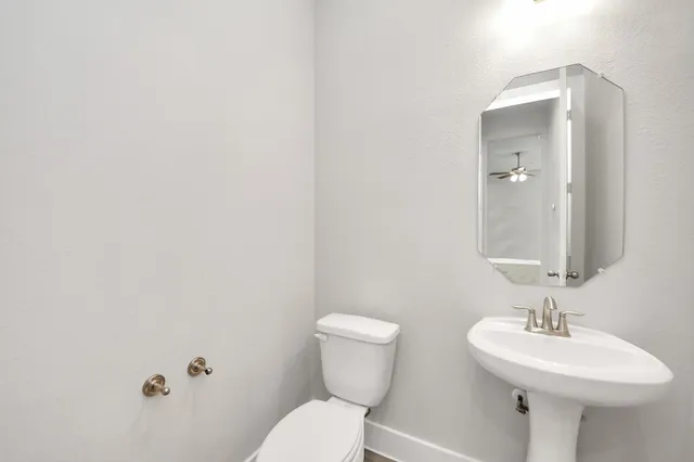 a bathroom with a sink mirror and toilet