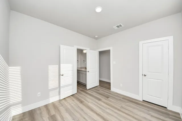 an empty room with closet and windows