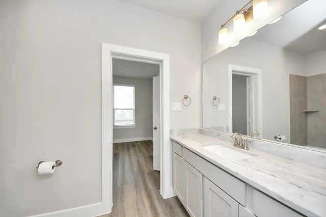 a bathroom with a granite countertop sink and a mirror