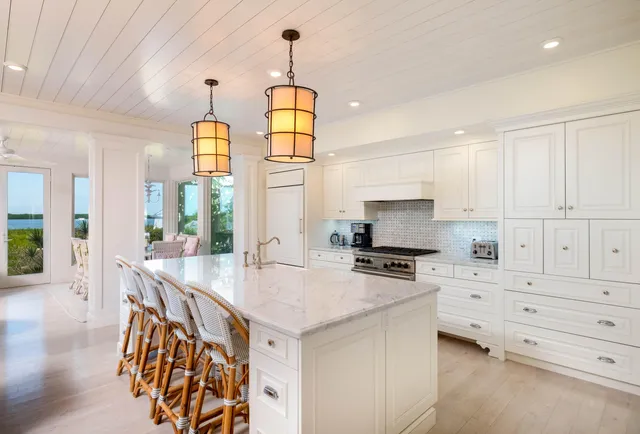 a kitchen with stainless steel appliances granite countertop a dining table chairs sink and cabinets