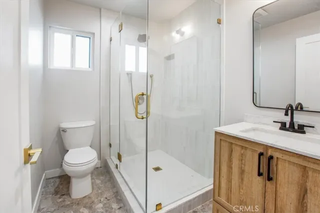 a bathroom with a granite countertop sink toilet and shower