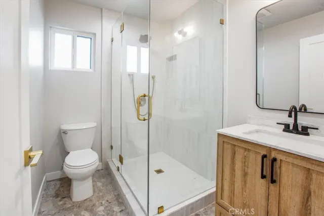 a bathroom with a granite countertop sink toilet and shower
