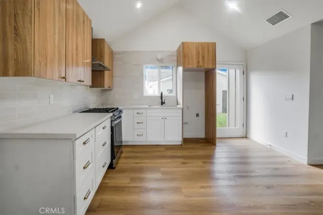a kitchen with granite countertop a refrigerator and a stove top oven
