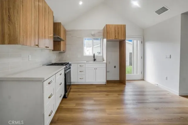 a kitchen with granite countertop a refrigerator and a stove top oven