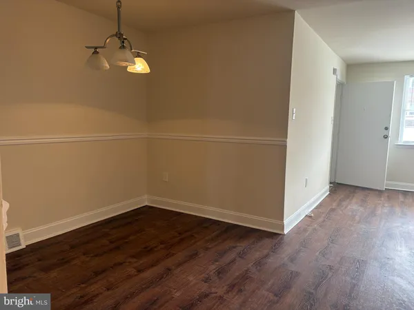 a view of a room with wooden floor and white walls