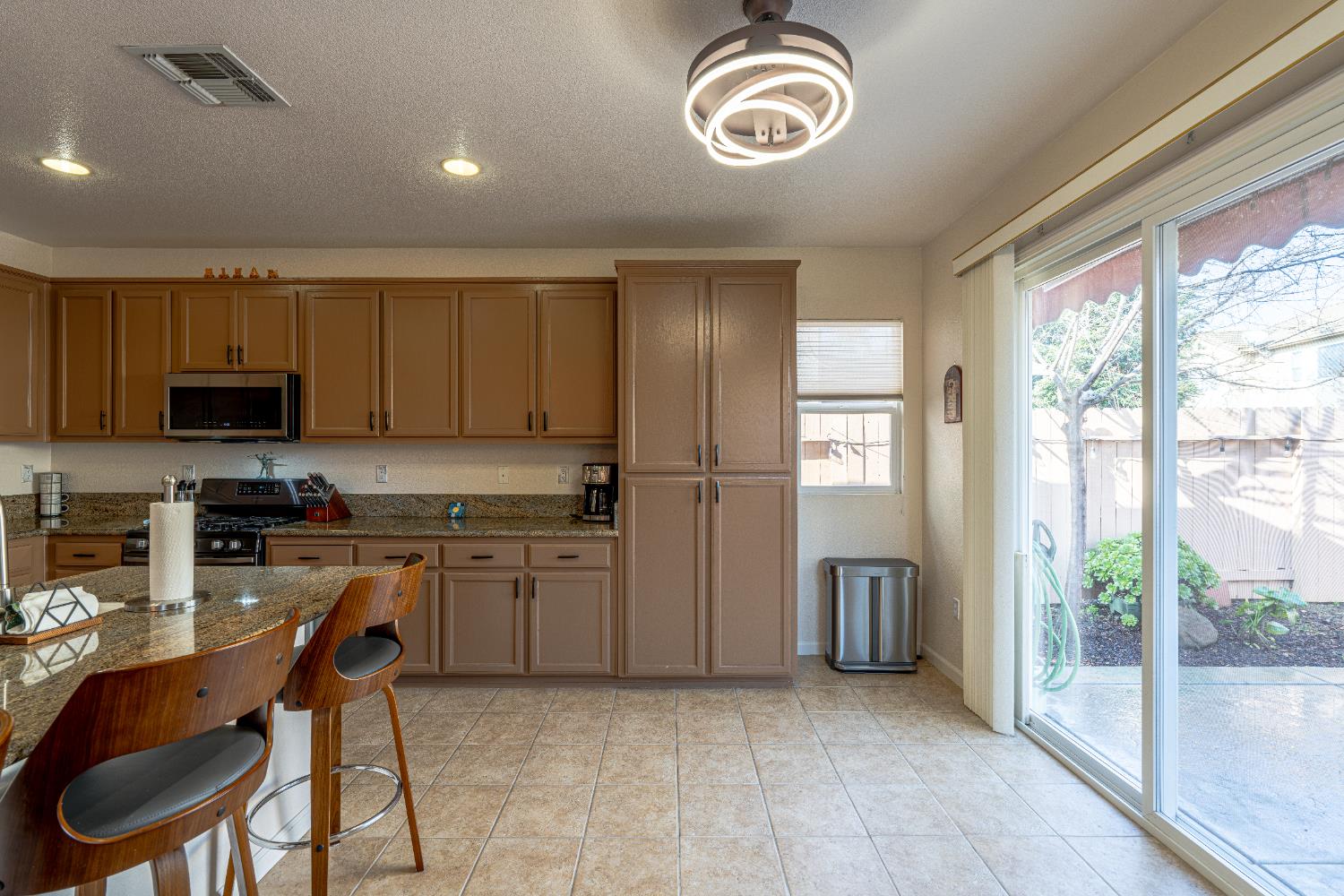 3710 Huntington Road West Sacramento, CA 95691 - Photo 12 of 46 a kitchen with stainless steel appliances granite countertop a stove top oven a refrigerator a sink and dishwasher with a dining table