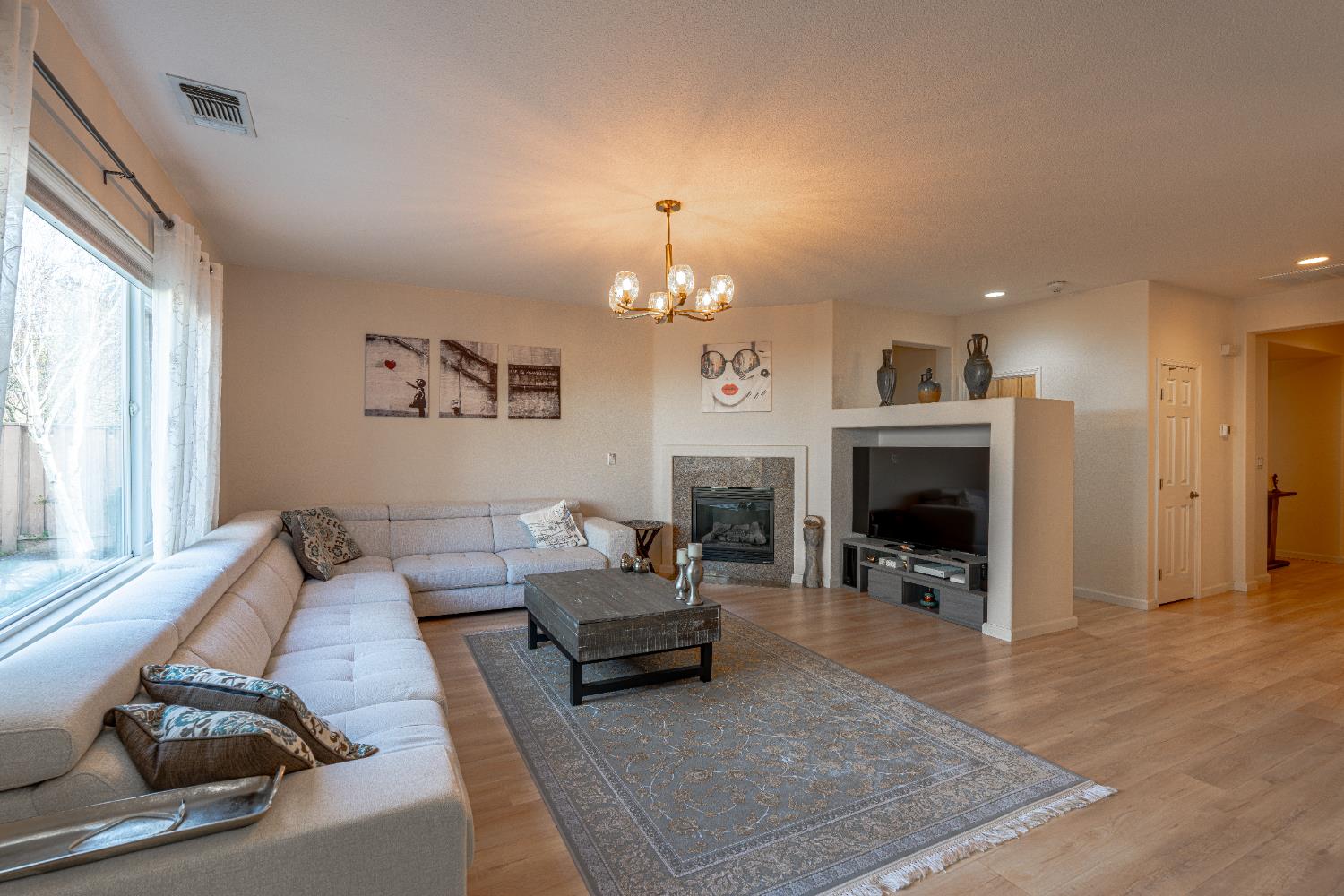 3710 Huntington Road West Sacramento, CA 95691 - Photo 9 of 46 a living room with furniture a fireplace and a chandelier