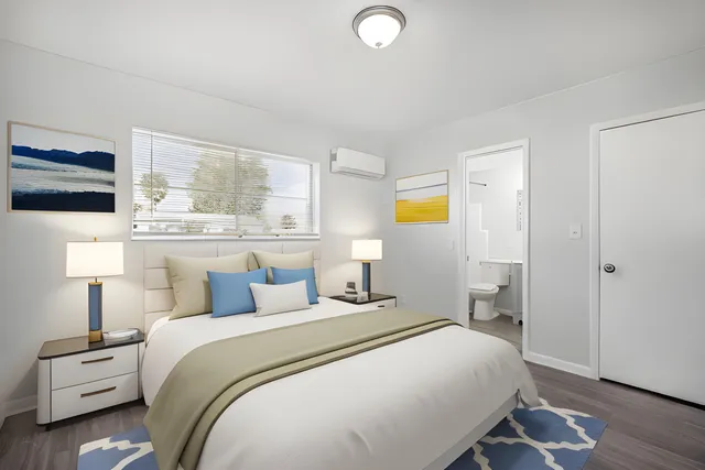 a bedroom with a bed and wooden floor