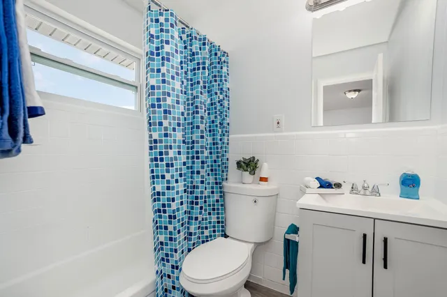 a bathroom with a sink a toilet and shower curtain