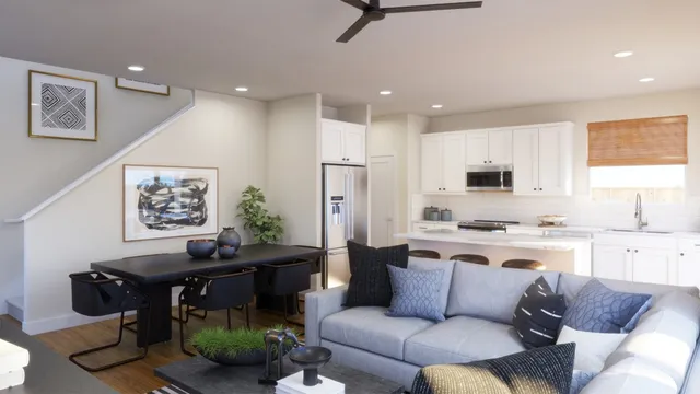a living room with stainless steel appliances furniture and a kitchen