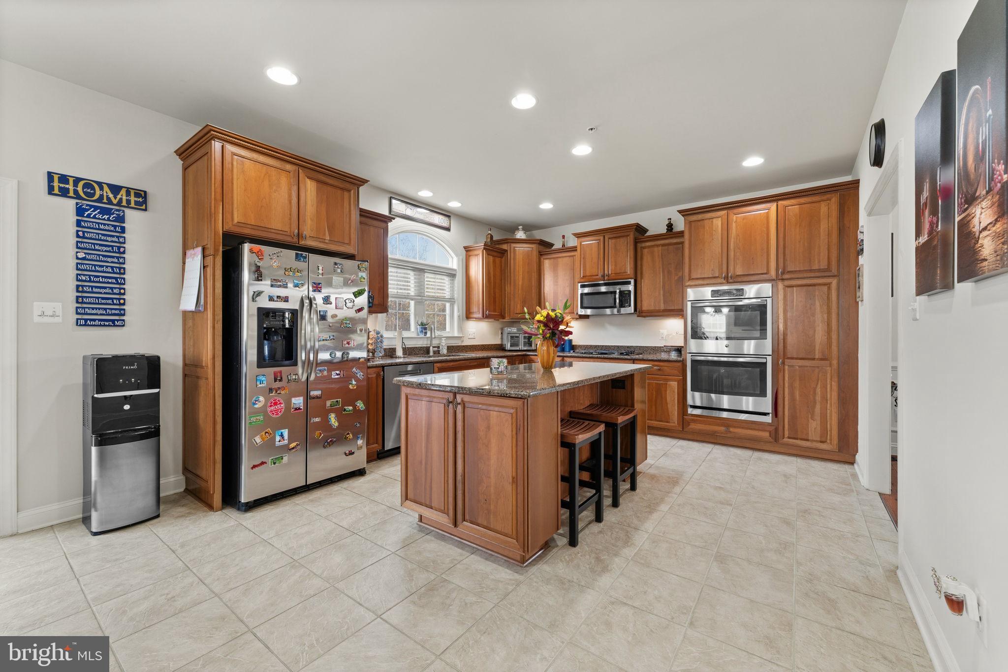4505 Coachmans Path Court Waldorf, MD 20601 - Photo 20 of 71 a kitchen with stainless steel appliances kitchen island granite countertop a refrigerator and a stove top oven