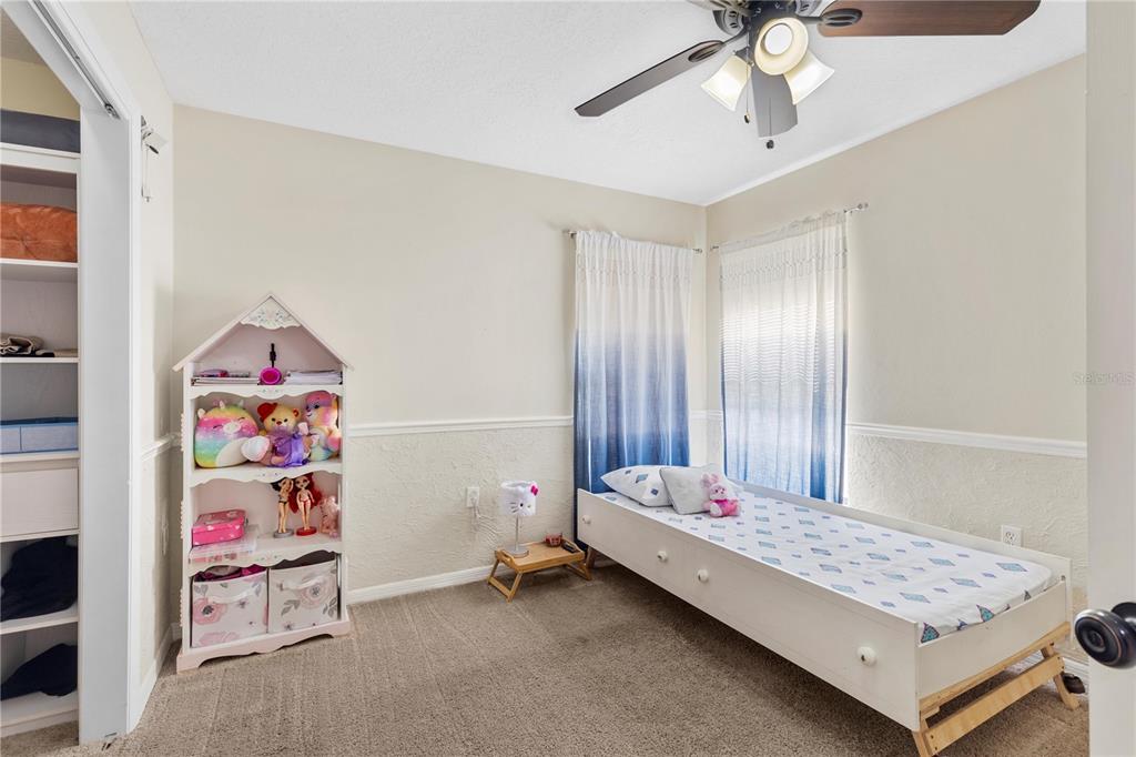 13481 Pullman Drive Spring Hill, FL 34609 - Photo 17 of 41 a bedroom with a bed and a chandelier