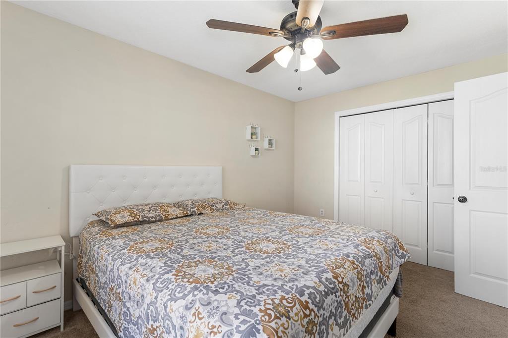 13481 Pullman Drive Spring Hill, FL 34609 - Photo 19 of 41 a bedroom with a bed and a ceiling fan