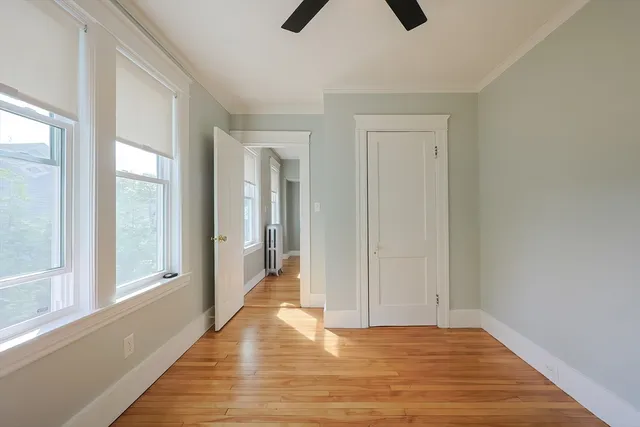 a view of an empty room and window and wooden floor
