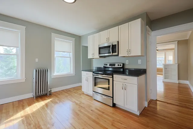 a kitchen with granite countertop white cabinets and appliances