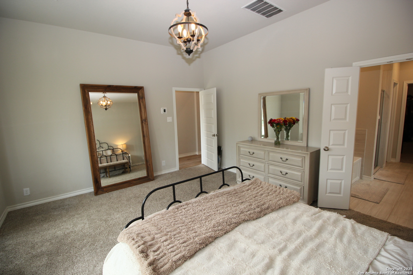 12228 Buckaroo Ranch San Antonio, TX 78254 - Photo 13 of 43 a bedroom with a bed and a chandelier