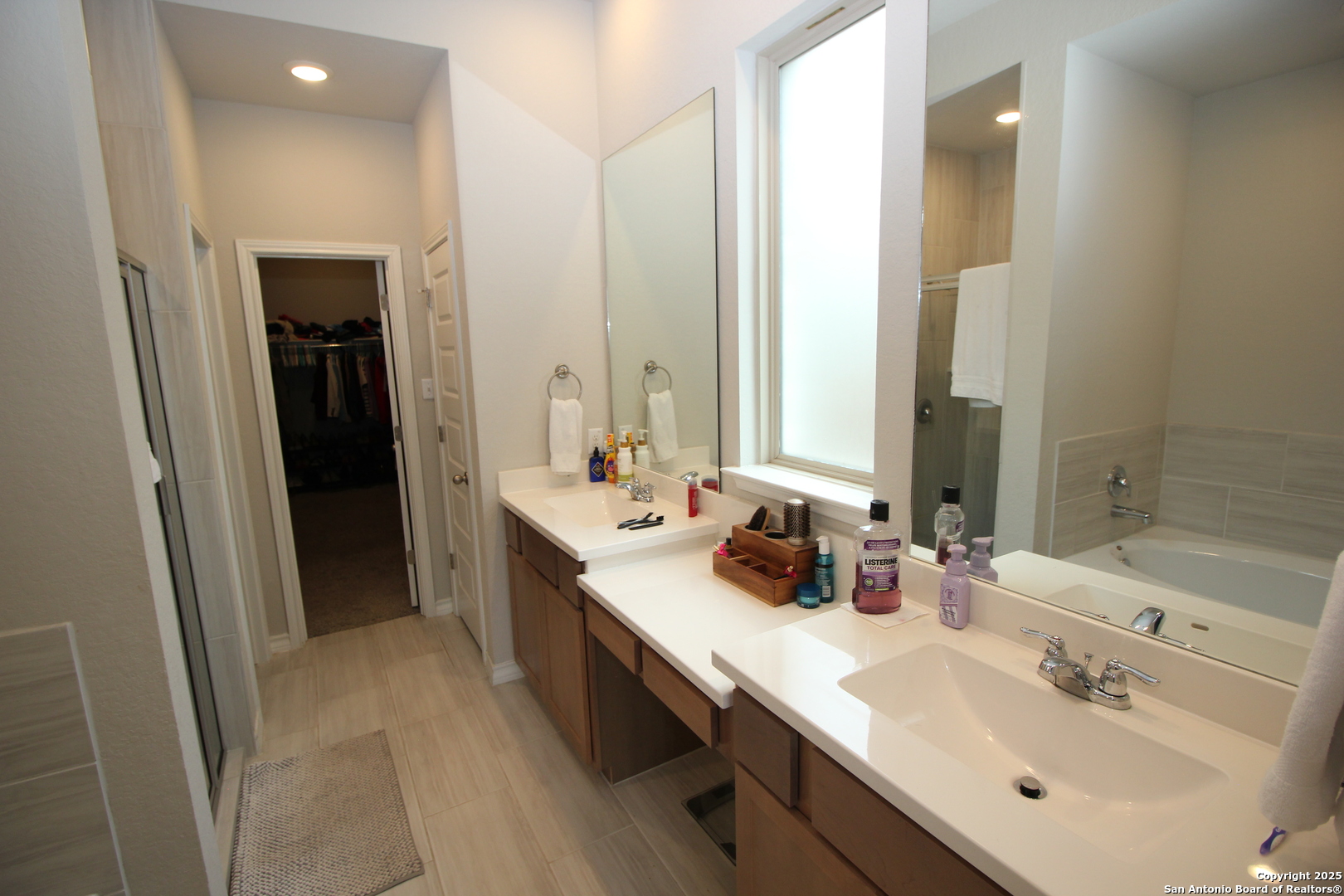 12228 Buckaroo Ranch San Antonio, TX 78254 - Photo 15 of 43 a bathroom with double vanity sinks and a mirror