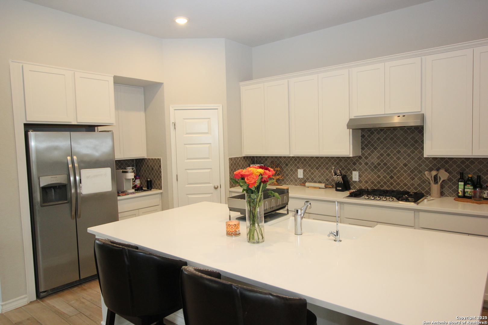 12228 Buckaroo Ranch San Antonio, TX 78254 - Photo 10 of 43 a kitchen with a sink a refrigerator and cabinets