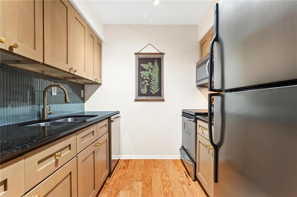 1150 Collier Road Northwest, Unit A10 Atlanta, GA 30318 - Photo 11 of 34 a kitchen with stainless steel appliances granite countertop a refrigerator and a sink