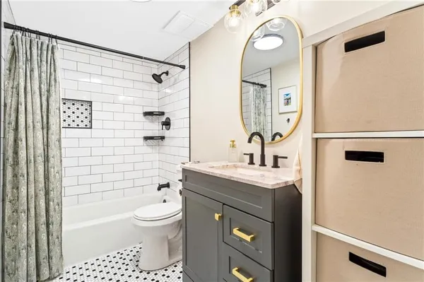 a bathroom with a granite countertop sink a toilet and shower
