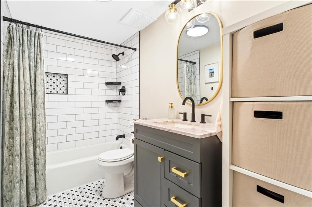 1150 Collier Road Northwest, Unit A10 Atlanta, GA 30318 - Photo 20 of 34 a bathroom with a granite countertop sink a toilet and shower